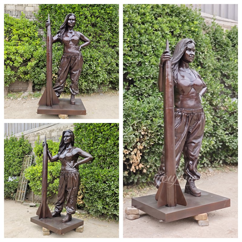 bronze woman holding a rocket sculpture